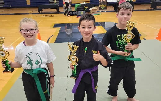 a group of kids holding trophies