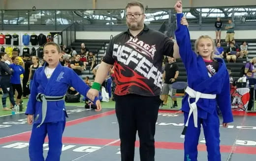 a person and two children in a wrestling ring