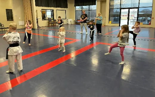 a group of children playing on a red and black floor