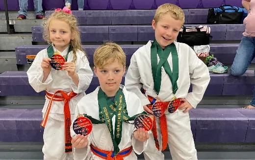 a group of children holding medals