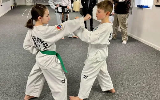 a couple of kids in karate uniforms