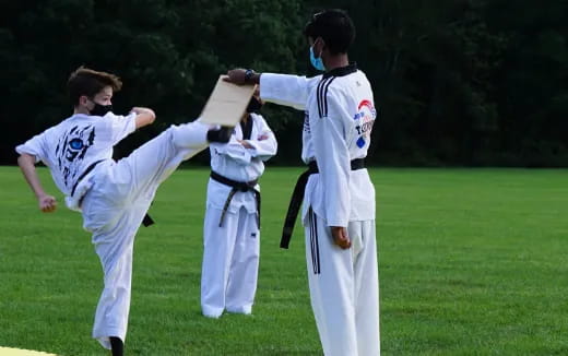 a group of people in white karate uniforms on a field