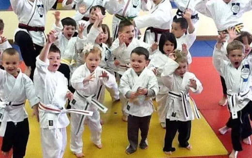 a group of children in white karate uniforms