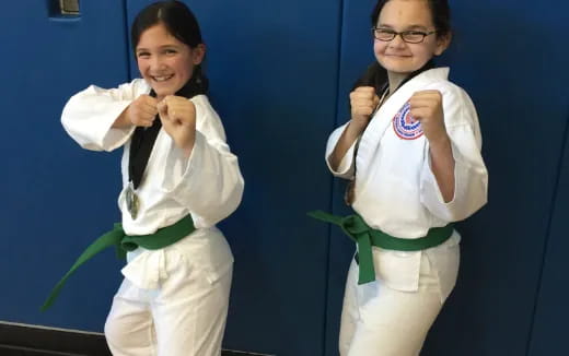 a couple of girls in karate uniforms