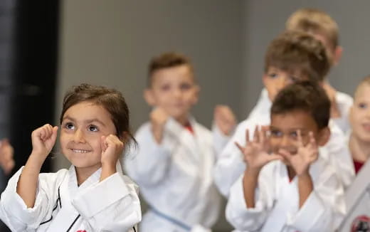 a group of children in white uniforms