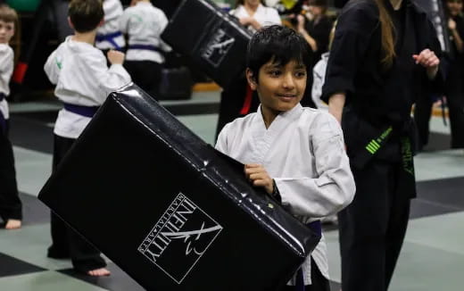 a young boy holding a black umbrella
