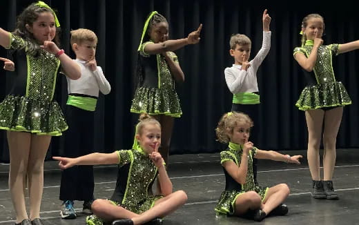 a group of children in green dresses