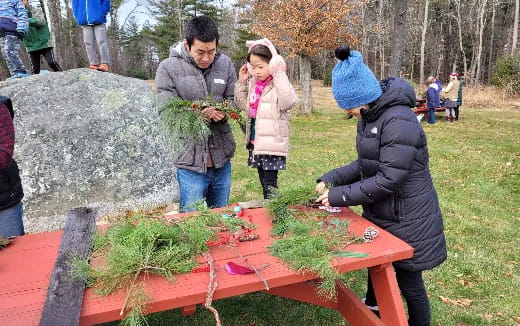 a group of people around a table with plants on it