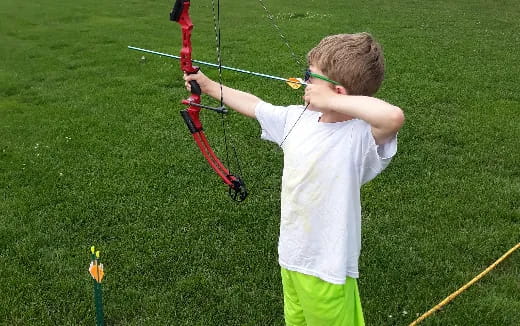 a boy holding a bow and arrow