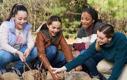 a group of women sitting on a rock