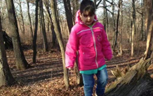 a person in a pink jacket in a forest