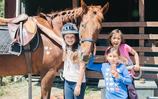 a group of children posing for a photo with a horse