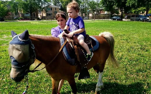a couple of children riding a horse