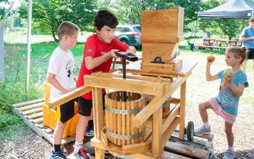 a group of kids playing with a wooden structure