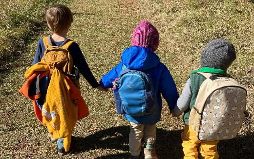 a group of children walking in the grass