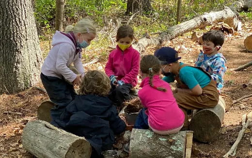 a group of children sitting on a log