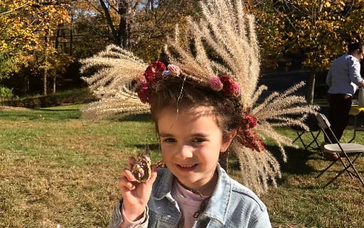 a girl holding a small pine cone
