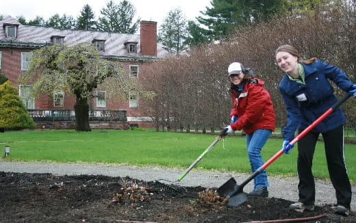 a couple of people shoveling dirt