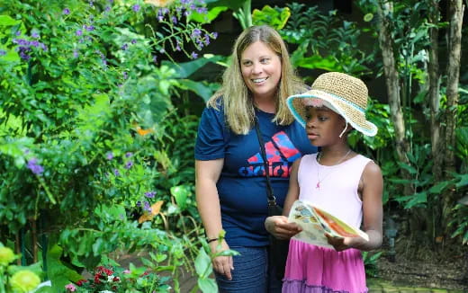 a person and a girl standing in a garden