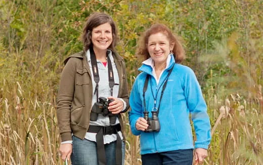 a couple of women standing in a field