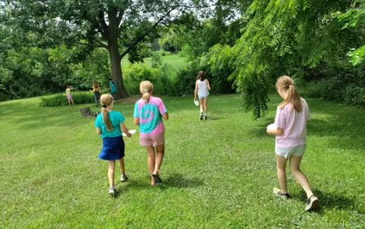 a group of people playing frisbee in a park