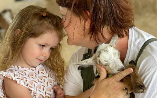 a person and a child holding a dog