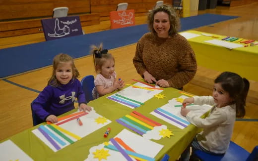 a person and several children sitting at a table