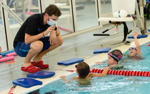 a person spraying a boy in a pool