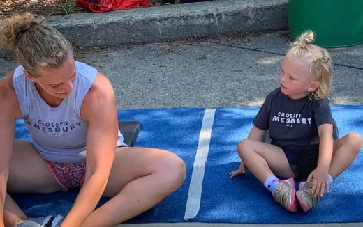a person and a child sitting on a mat