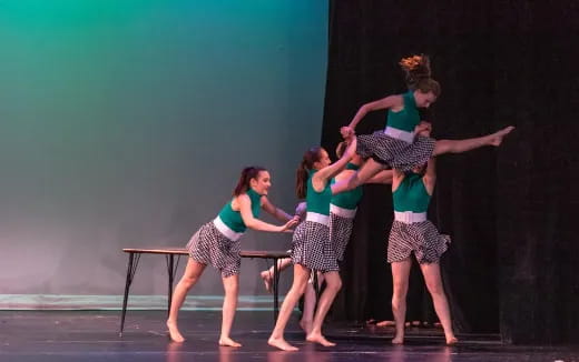 a group of girls dancing on a stage