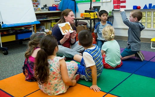 a group of children sitting on the floor eating