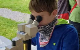 a boy looking at a robot