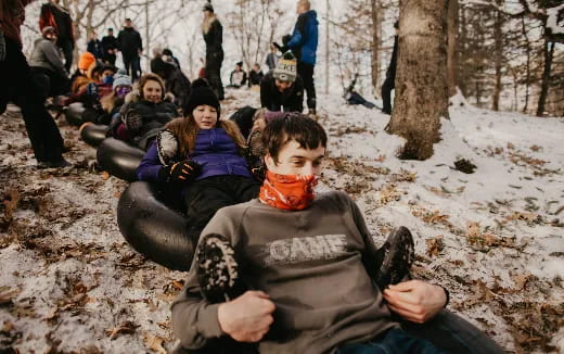 a group of people sitting in the snow