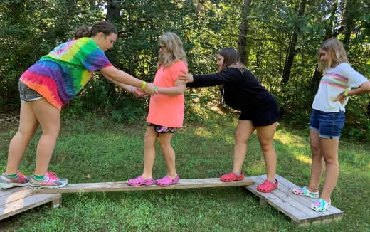 a group of children playing on a wooden bench
