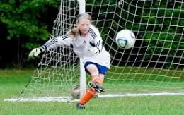 a girl kicking a football ball