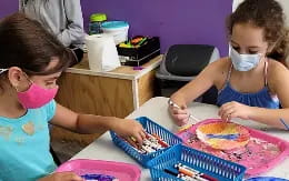 a couple of young girls eating cake