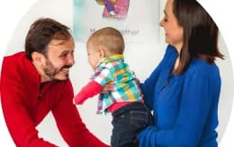 a man and woman holding a baby