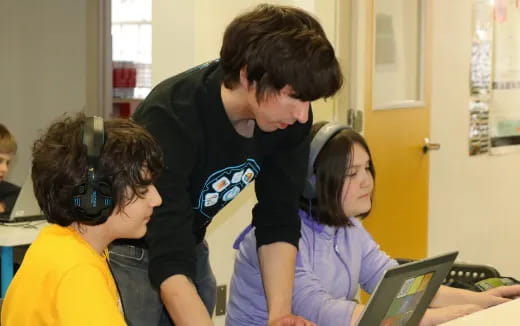 a group of people looking at a laptop