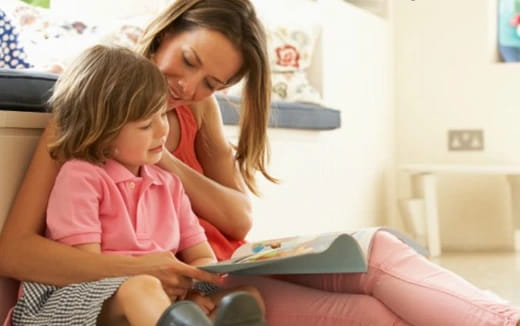 a woman reading a book to a young girl