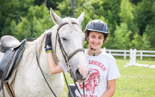 a boy with a helmet on a horse