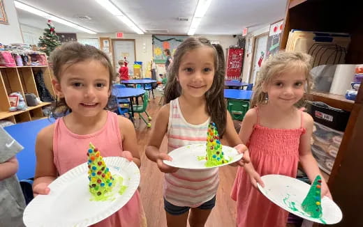 a group of girls holding plates of food