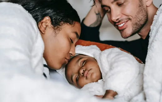 a man and woman holding a baby