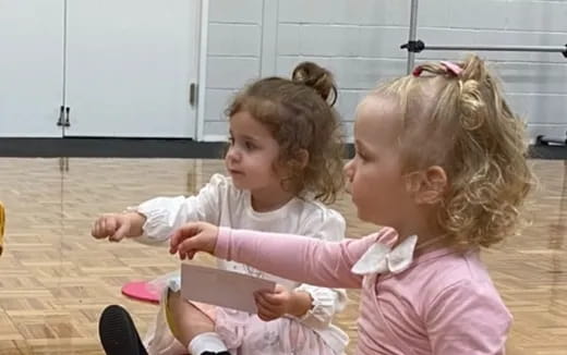 a couple of young girls playing with a toy