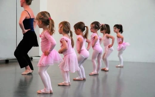 a group of girls in pink dresses