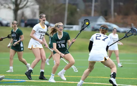 a group of women playing lacrosse