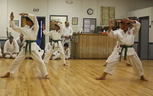 a group of people in white karate uniforms in a room