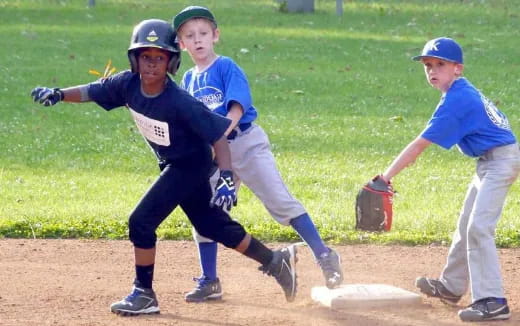 a group of kids playing baseball