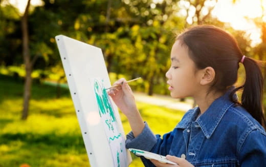 a young girl writing on a piece of paper