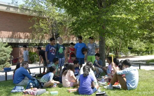 a group of people sitting on the grass