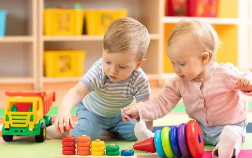 a couple of babies playing with toys